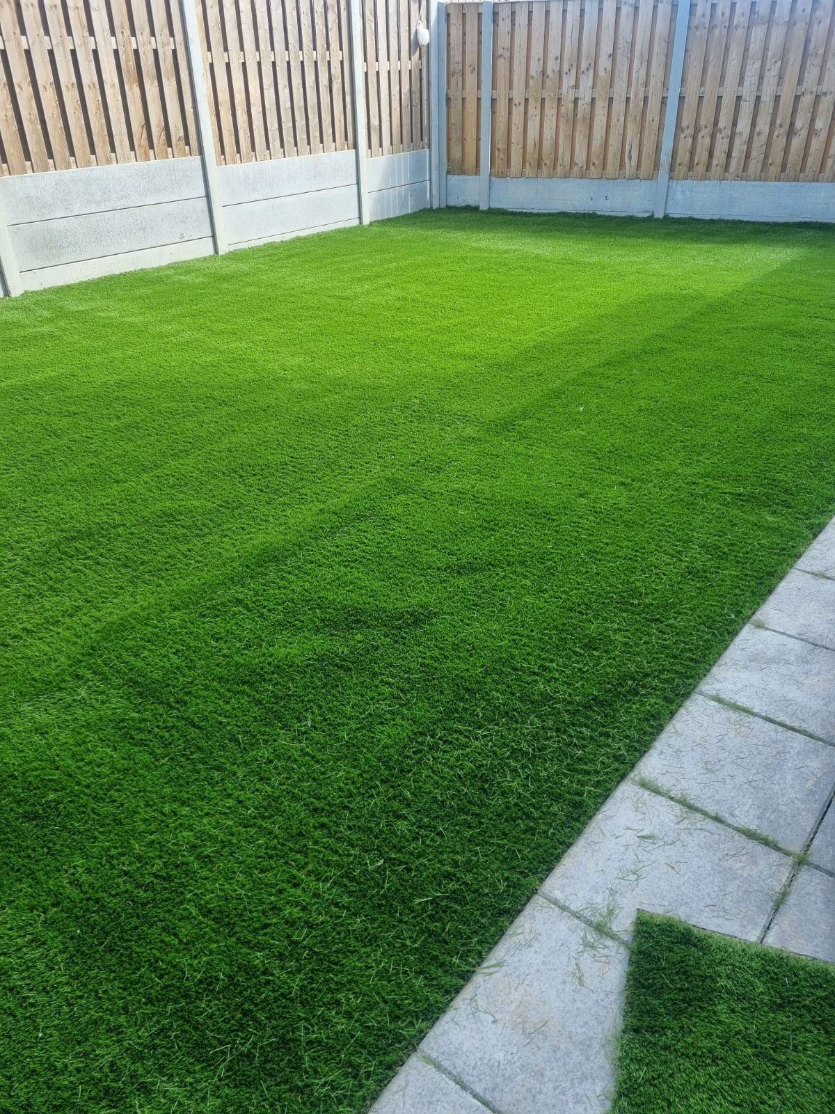 Image of 45mm artificial grass installation in the back patio and site passage in Lucan, County Dublin, showcasing a lush and vibrant outdoor space