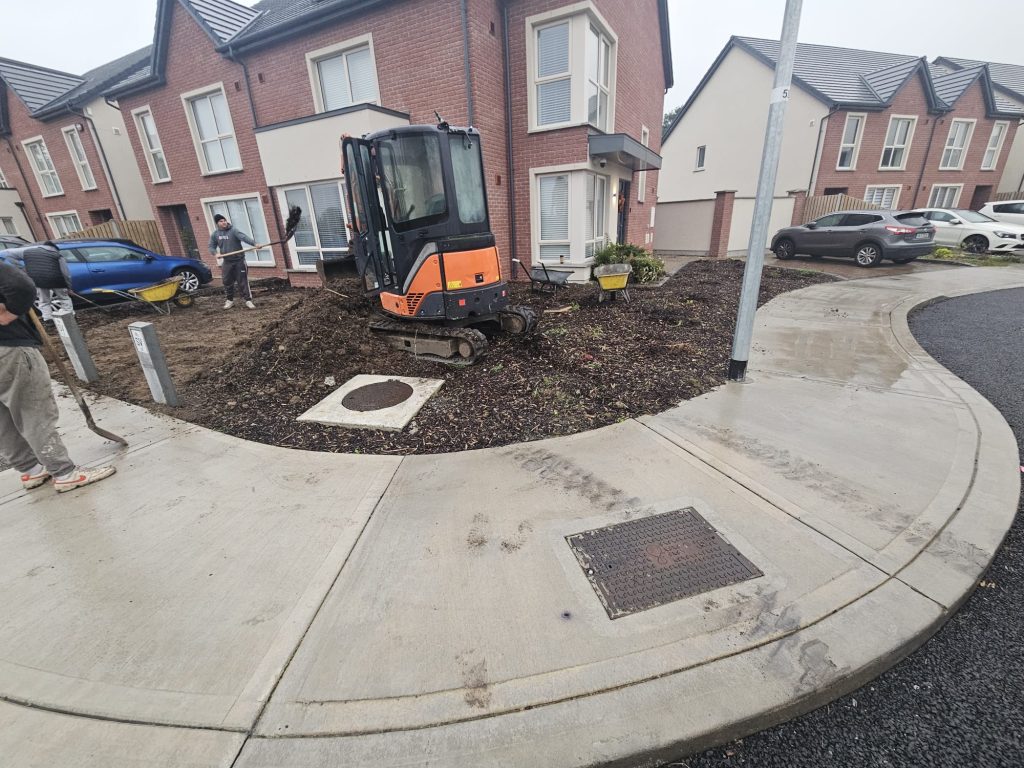 Digger removing soil and shrubs